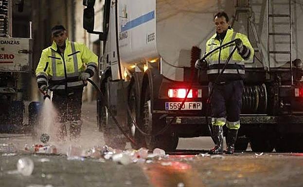 Operarios retiran los restos de una Nochevieja Universitaria.