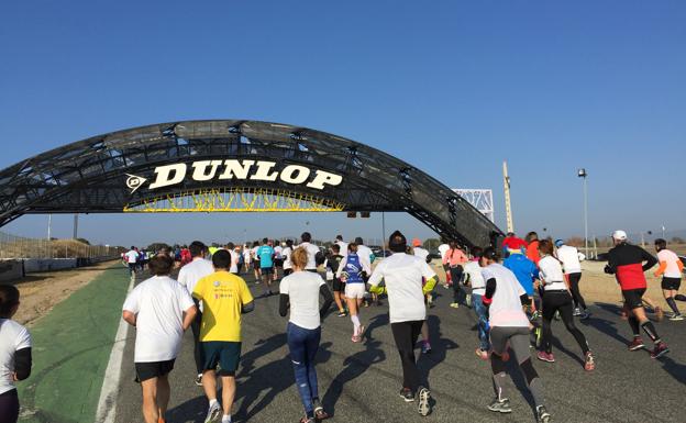 Los participantes de la carrera a través del Jarama.