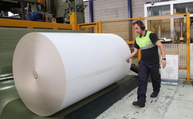 Un operario, junto a una bobina de papel estucado en la planta de Europac de Dueñas (Palencia).