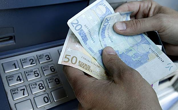 Una persona extrae dinero en efectivo de un cajero automático.