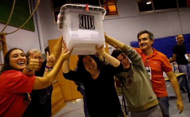 Voluntarios alzan una urna el 1 de octubre.