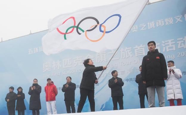 La secretaria general del Comité Organizador de los Juegos Olímpicos de Invierno de Pekín ondea la bandera olímpica. 