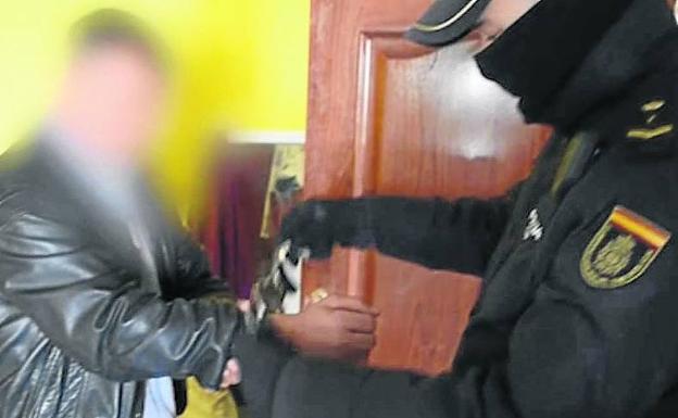 Un policía esposa al principal sospechoso de la venta de las jóvenes, de 16 y 17 años, que ha sido enviado a prisión.