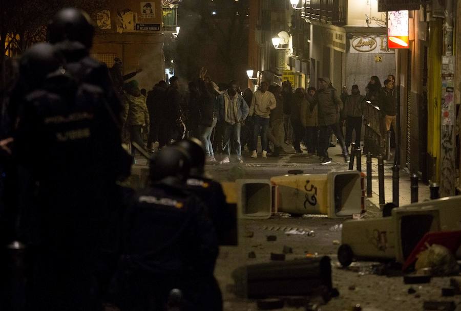 Un grupo de más de medio centenar de personas han quemado contenedores y causado desperfectos en el mobiliario urbano en el madrileño barrio de Lavapiés tras la muerte este jueves de un mantero de 35 años y origen subsahariano a causa de una parada cardiorrespiratoria.