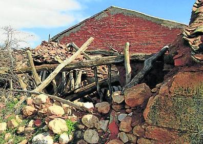 Imagen secundaria 1 - Arriba, un hotel rural cerrado; abajo, casas derruidas y a medio hacer en Barahona de Fresno. 