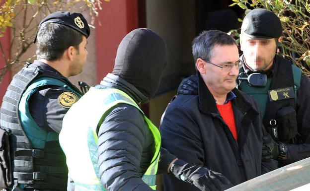 El investigado es introducido en un vehículo policial tras su detención. 