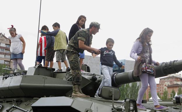 Los soldados enseñan a los niños los objetos de la exposición del ejército en la Feria de Muestras de Valladolid.