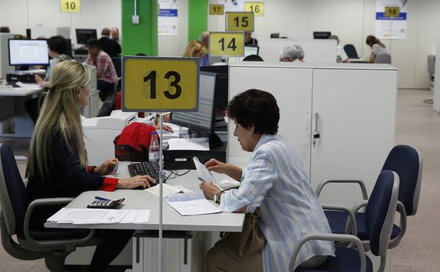 Una mujer obtiene asesoramiento en una oficina de la Agencia Tributaria.