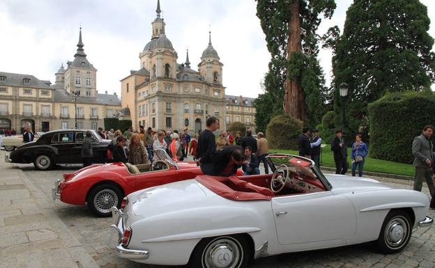 Decenas de personas contemplan los vehículos estacionados en las inmediaciones del Palacio Real. 