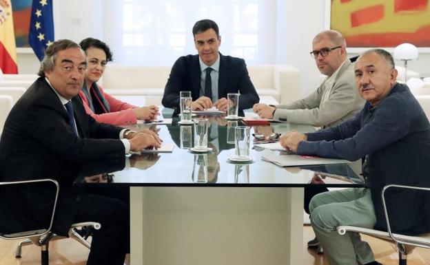 Pedro Sánchez (c) y la ministra de trabajo Magdalena Valerio, durante la reunión con los agentes sociales. 