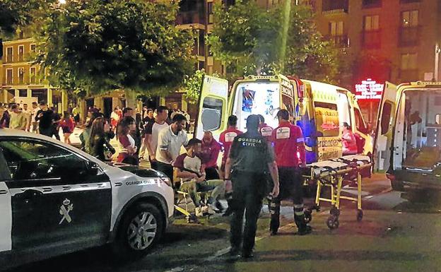 Los sanitarios trasladan a los heridos en la reyerta registrada en la Plaza Mayor de La Cistérniga en presencia de los guardias civiles.