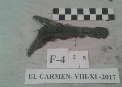 Imagen secundaria 1 - Las seis fosas comunes se escondían bajo uno de los caminos del cementerio de El Carmen. Dos de los objetos extraídos de las fosas: la cremallera de un jersey y un pin con dos gatos que está siendo estudiado en el Museo de Núremberg.