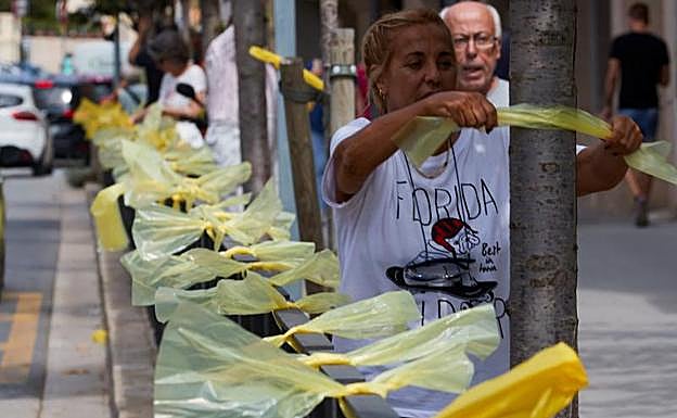 Una señora coloca lazos amarillos en la localidad barcelonesa de Alella. 