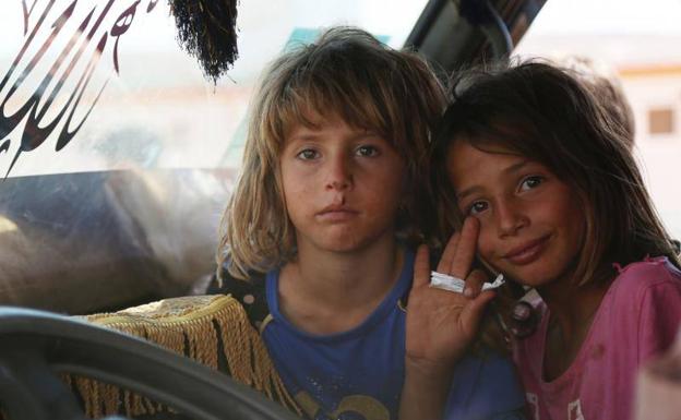 Dos niños huyen de Iblid junto a su familia.