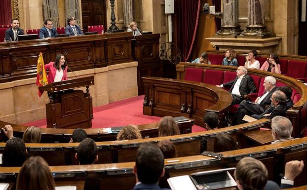 La líder de Ciudadanos, Inés Arrimadas (i), muestra una bandera española durante el turno de réplica. 