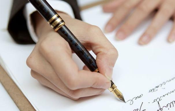 Una mujer escribe con una pluma estilográfica. 