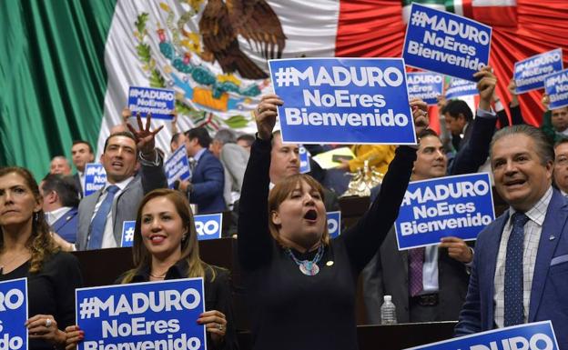 Diputados mexicanos protestan por la invitación que el partido Morena, del futuro presidente de México, Andrés Manuel López Obrador, le ha hecho al presidente de Venezuela, Nicolás Maduro, para que asista a la toma de posesión el próximo 1 de diciembre, durante una sesión ordinaria, en Ciudad de México (México). 