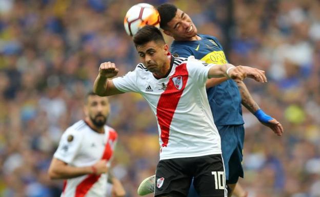 Jugadores de River y Boca pelean por un balón.