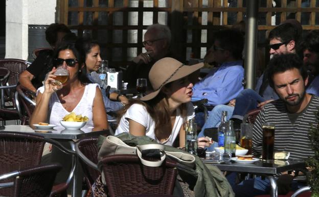 Clientes disfrutan del veranillo de San Martín en una terraza, el año pasado.