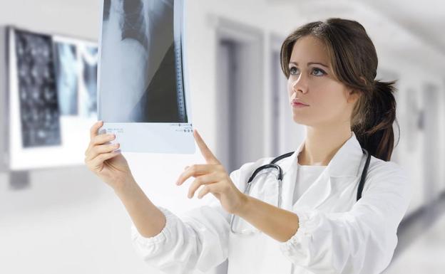 Una médico consulta una radiografía.