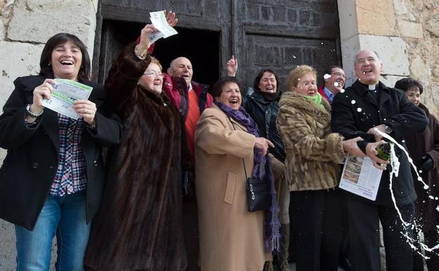 Heriberto García, párroco de Peñaranda de Duero, celebra el cuarto premio junto a vecinos del pueblo. 