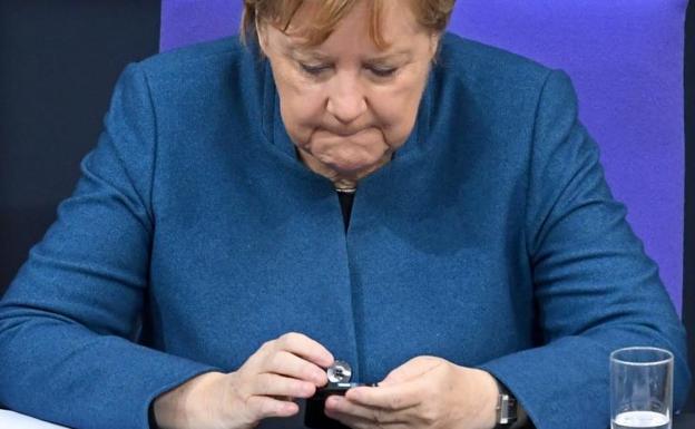 La canciller Angela Merkel utiliza su teléfono móvil en el parlamento alemán. 