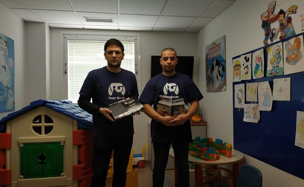 Miembros de la Asociación Riber Games muestran la videoconsola donada. 