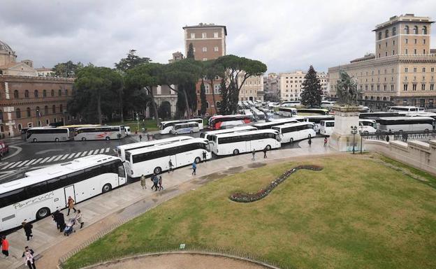 Varios autobuses de turistas aparcados en la Piazza Venezia. 