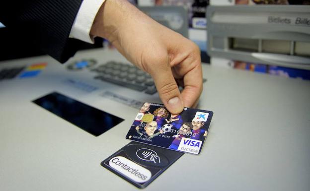 Un hombre utiliza una tarjeta bancaria. 