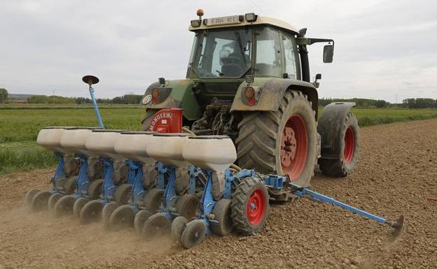 Un agricultor realiza tareas de siembra con su tractor.