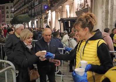 Imagen secundaria 1 - Aspecto de la Plaza Mayor instantes antes de comenzar el pregón (arriba), una peñista de BurgoSalsón entrega una vaso de sopas de ajo a una pareja (izquierda) y Romina Ventín, leyendo el pregón.