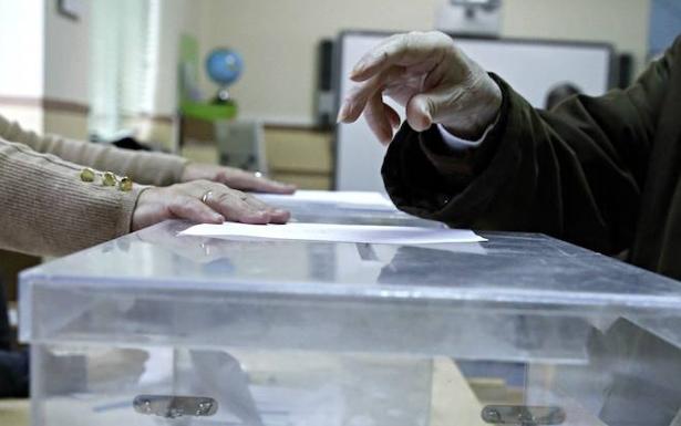 Un votante deposita su voto en una urna.