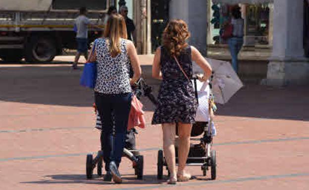 Dos mujeres paseando con sus bebés.
