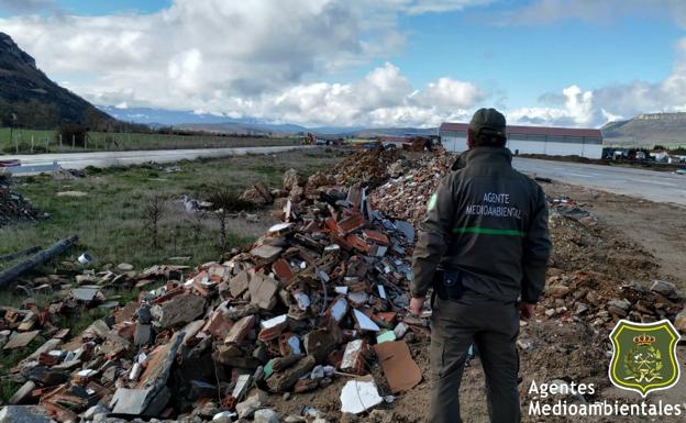 Uno de los agentes medioambientales observa el vertido ilegal de residuos de construcción aparecido en Merindad de Montija. 