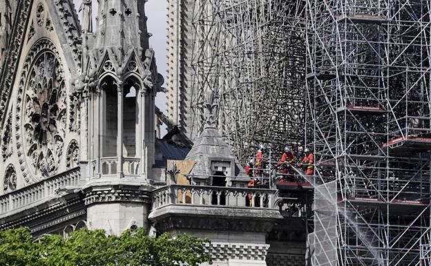 Uno de los frontones laterales de Notre Dame, con los bomberos que investigan su estado.