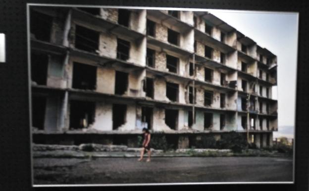 Una mujer armenia pasa al lado de un bloque de apartamentos destruido en la calle Baranda en la ciudad de Shushi. 