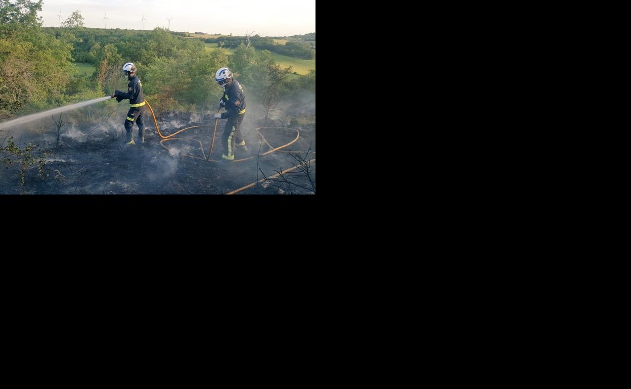 Una dotación de bomberos sofocando un incendio. 