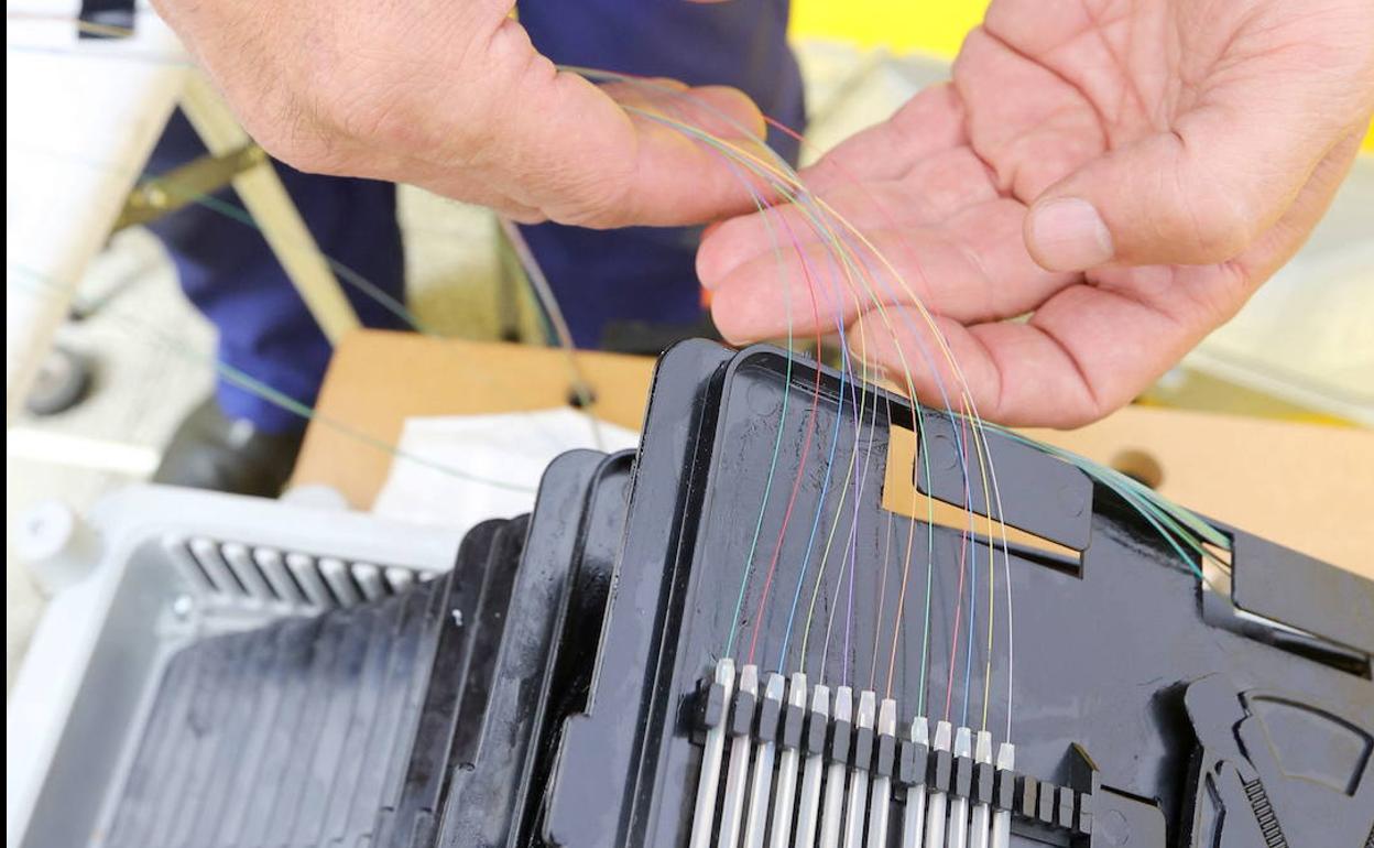 Trabajadores de Elecnor, una de las empresas que trabaja para Telefónica en el despliegue de fibra óptica, instalan las nuevas líneas en un centro de Valladolid. 