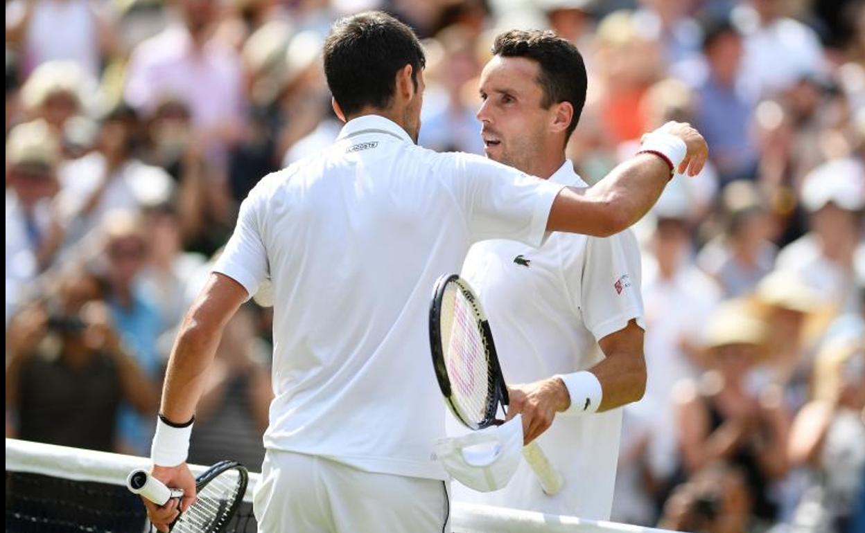 Novak Djokovic consuela a Roberto Bautista tras el partido. 