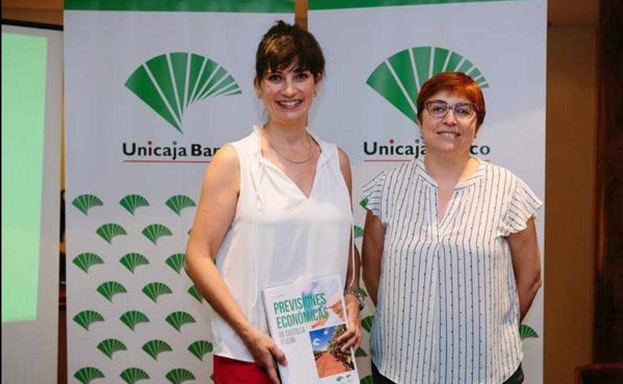 Felisa Becerro y Macarena García posan con el informe de Unicaja 