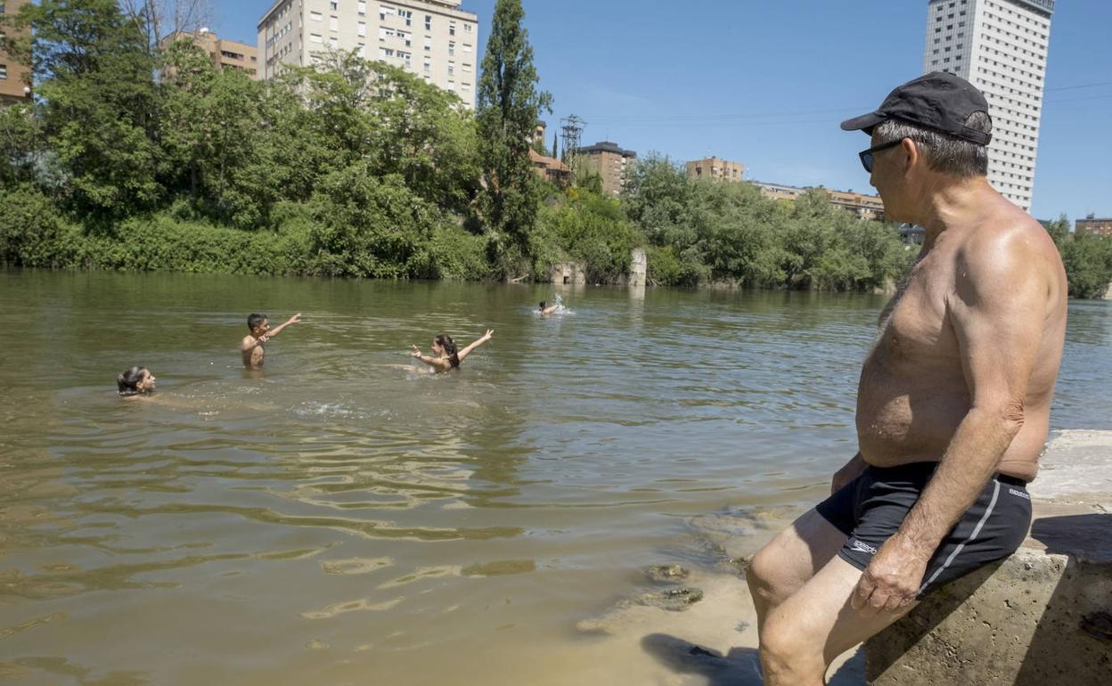 Un hombre se refresca en la playa de las Moreras de Valladolid.