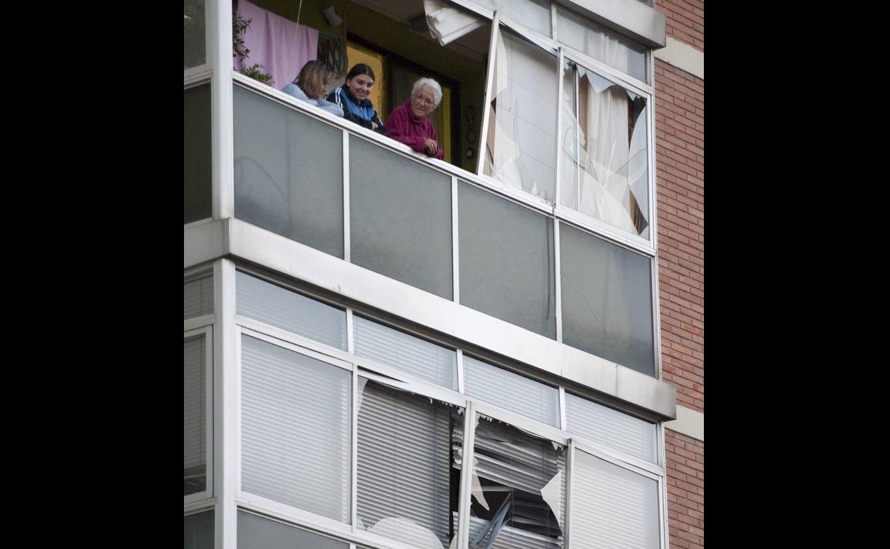 Unas vecinas de la casa cuartel se asoman a las ventanas, con desperfectos, para observar la situación. 