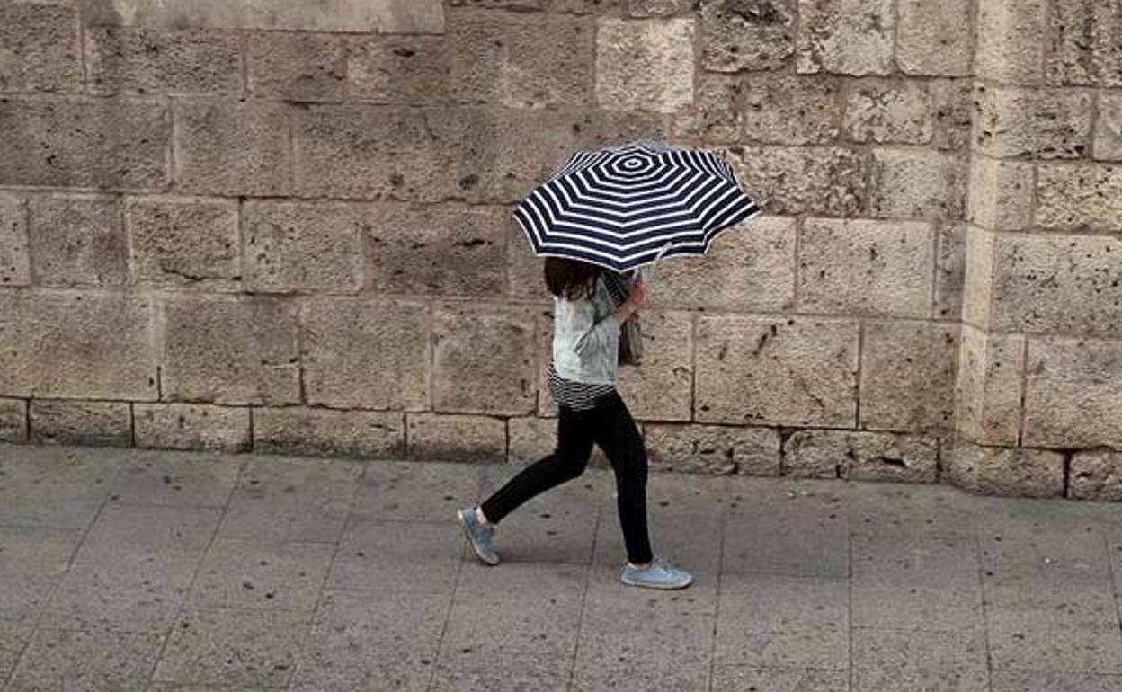 Imagen de archivo de una mujer durante una tormenta en Burgos.