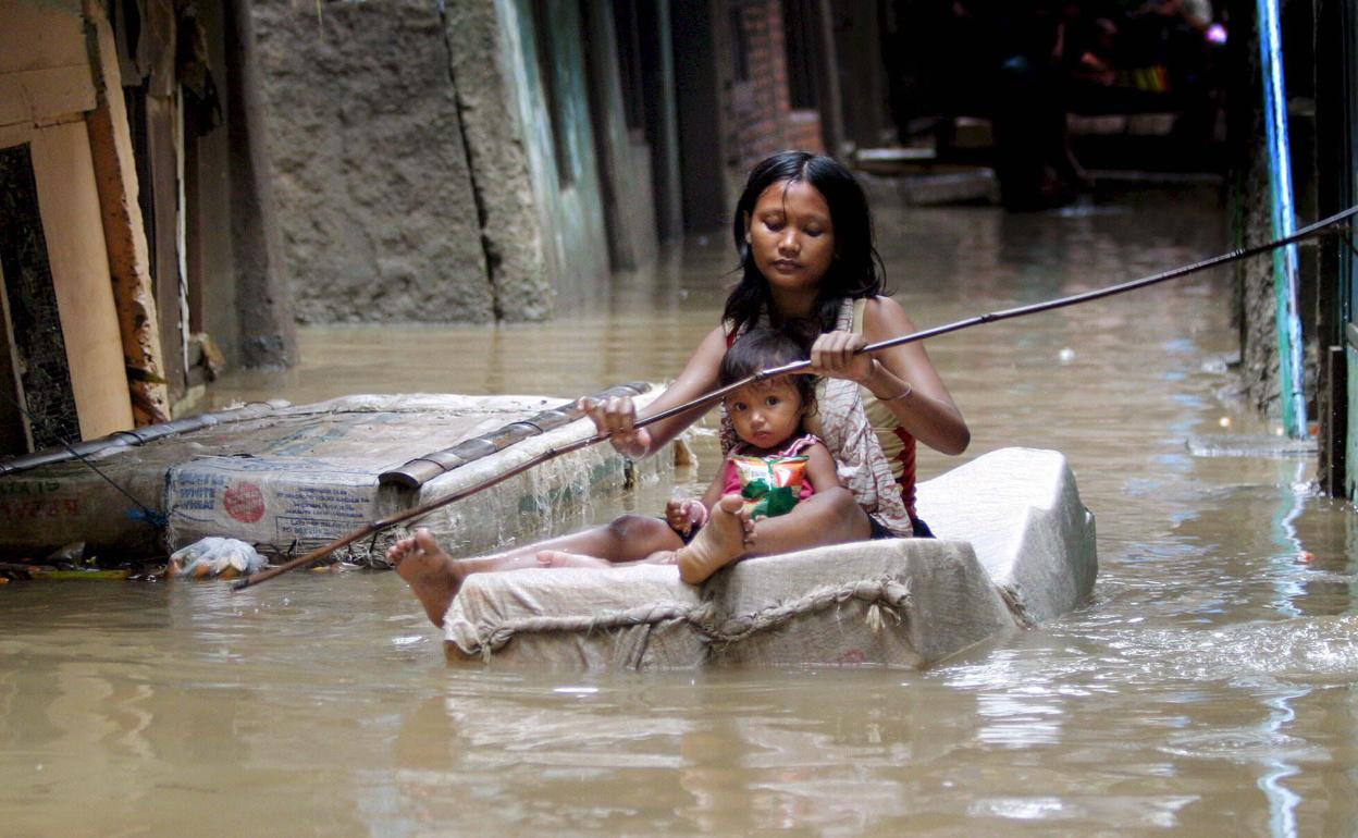 Una mujer indonesa y su hija usan una balsa de emergencia en un suburbio inundado de Yakarta, Indonesia el 31 de enero de 2007. 
