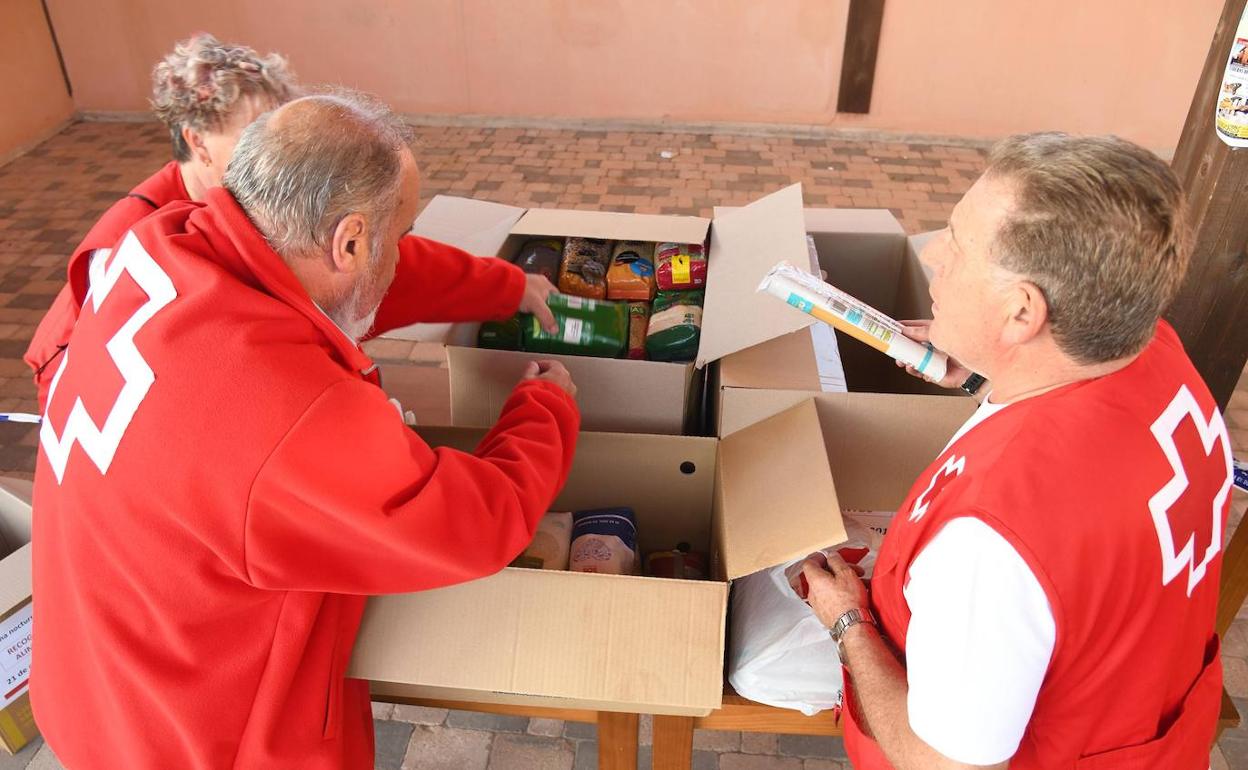 Miembros de la Cruz Roja recolectando la comida donada. 