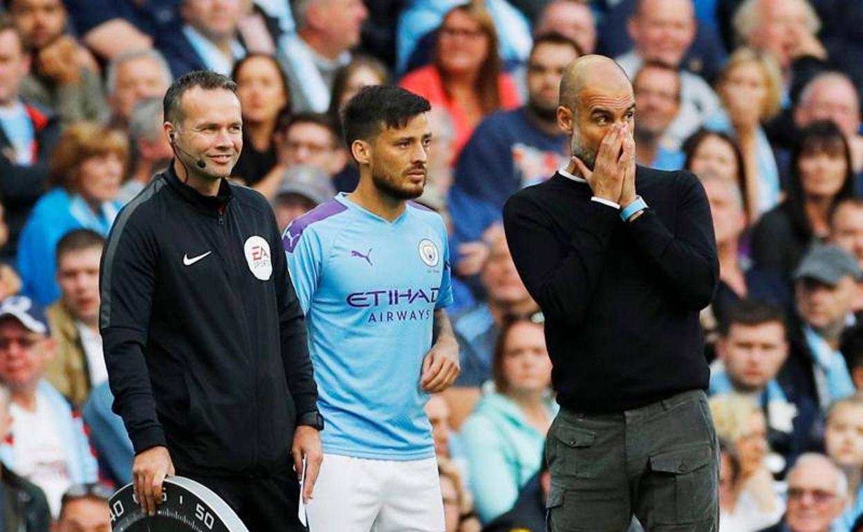 David Silva, junto a Pep Guardiola en la banda del Etihad Stadium.