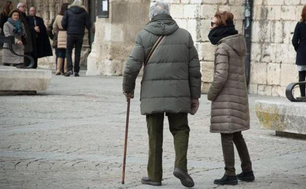 Una pareja de ancianos pasea por las inmediaciones de la iglesia de San Lesmes. 