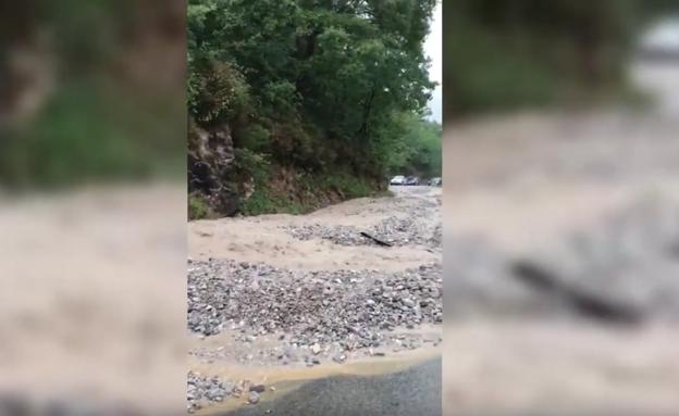 Imagen del agua y pedrisco cortando la carretera que une Caín y Posada de Valdeón. 