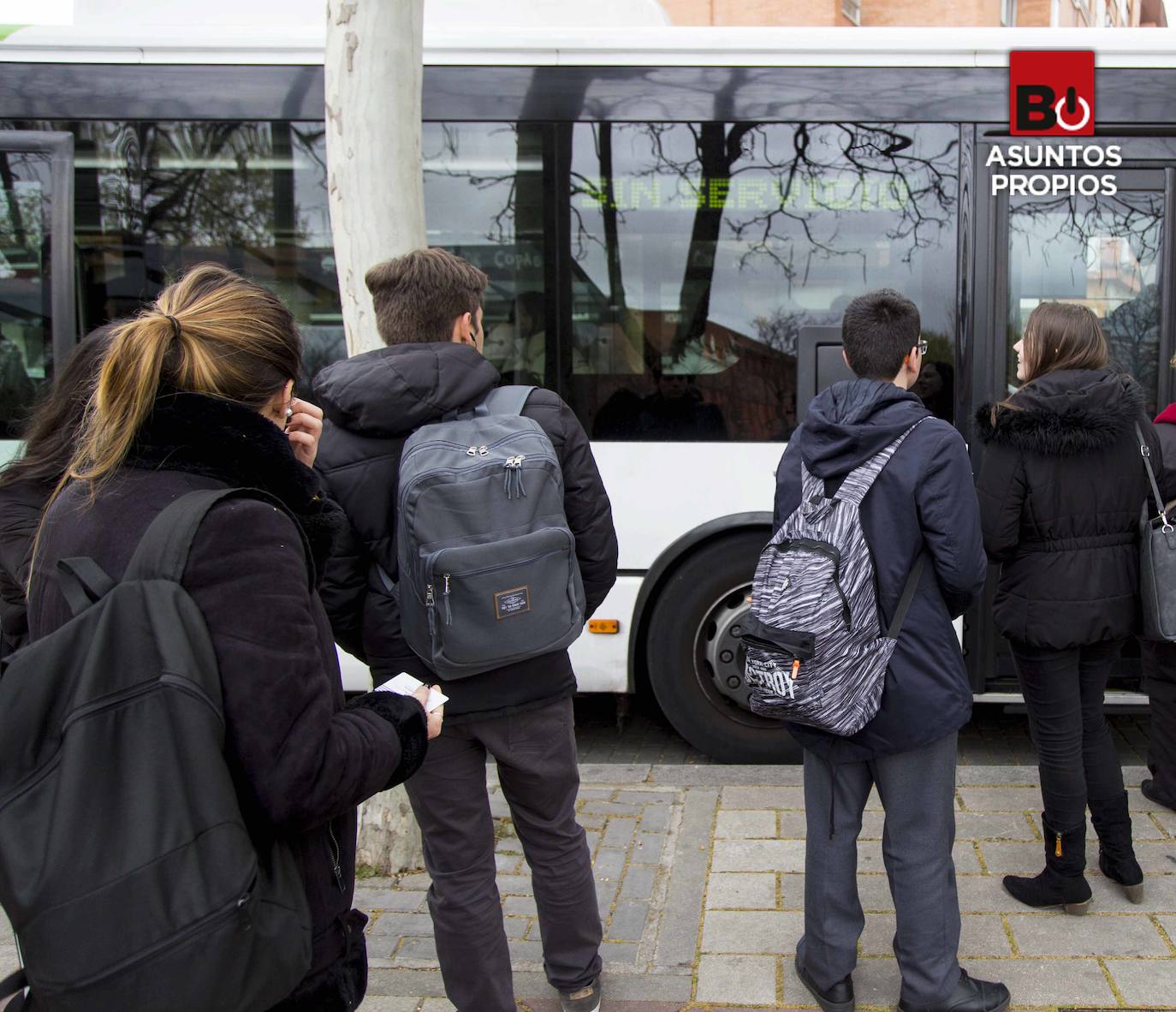 Jóvenes estudiantes esperan el autobús para ir al instituto. 