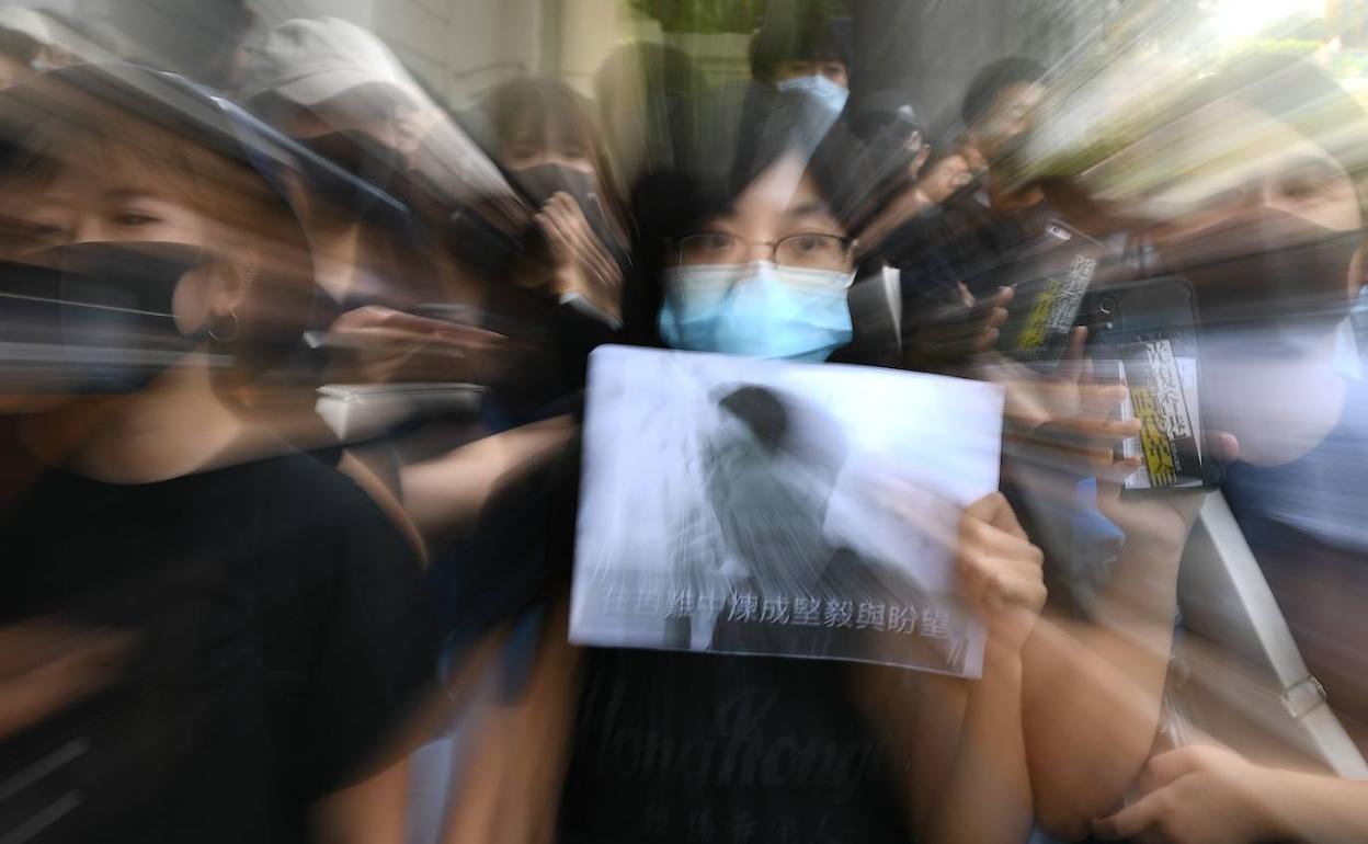 Manifestantes con máscaras a las puertas de los juzgados de Hong Kong, donde se sienta en el banquillo un conocido activista.